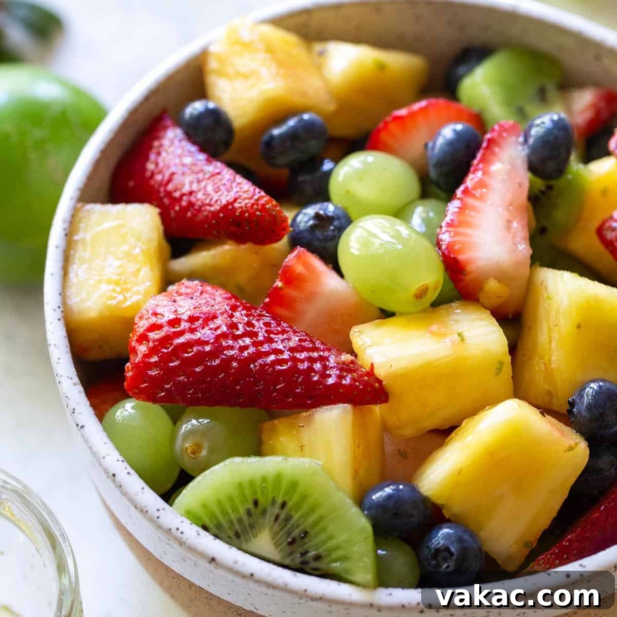 A white bowl filled with fresh fruit salad.