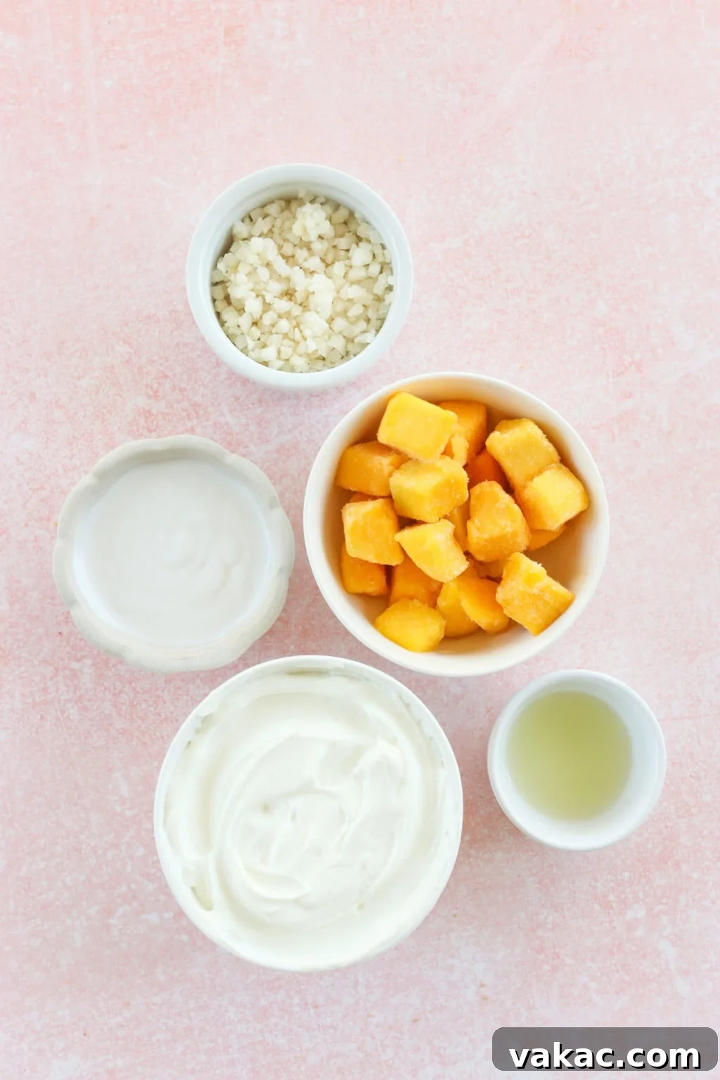 Paradise Protein Greek Yogurt Bowl 3 Ingredients for high protein tropical smoothie bowl with Greek yogurt in small white bowls, including Greek yogurt, mango, riced cauliflower, lime juice, milk of choice