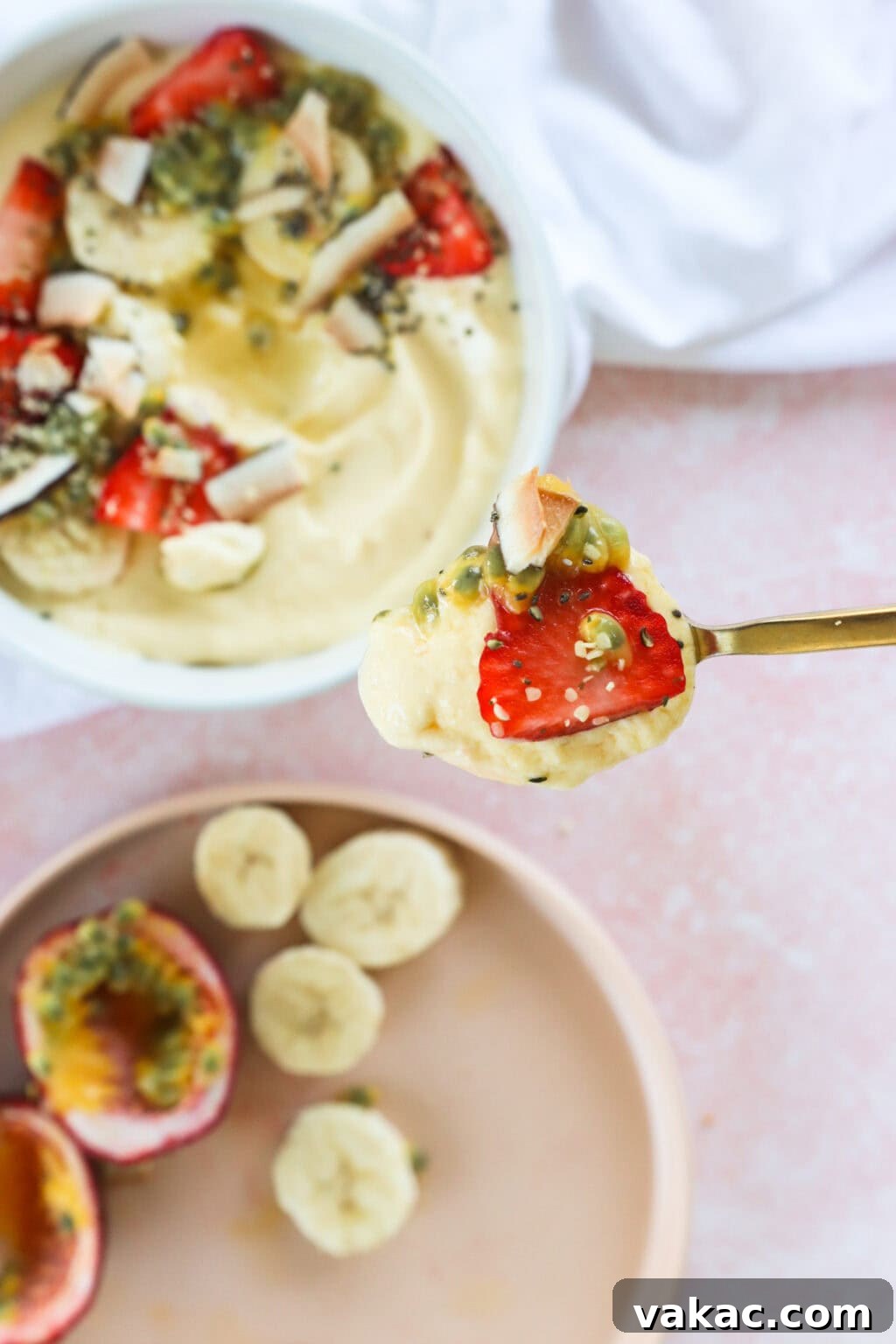 Paradise Protein Greek Yogurt Bowl 8 High Protein Tropical Smoothie Bowl with Greek Yogurt in a white bowl next to a gold spoon and white tablecloth