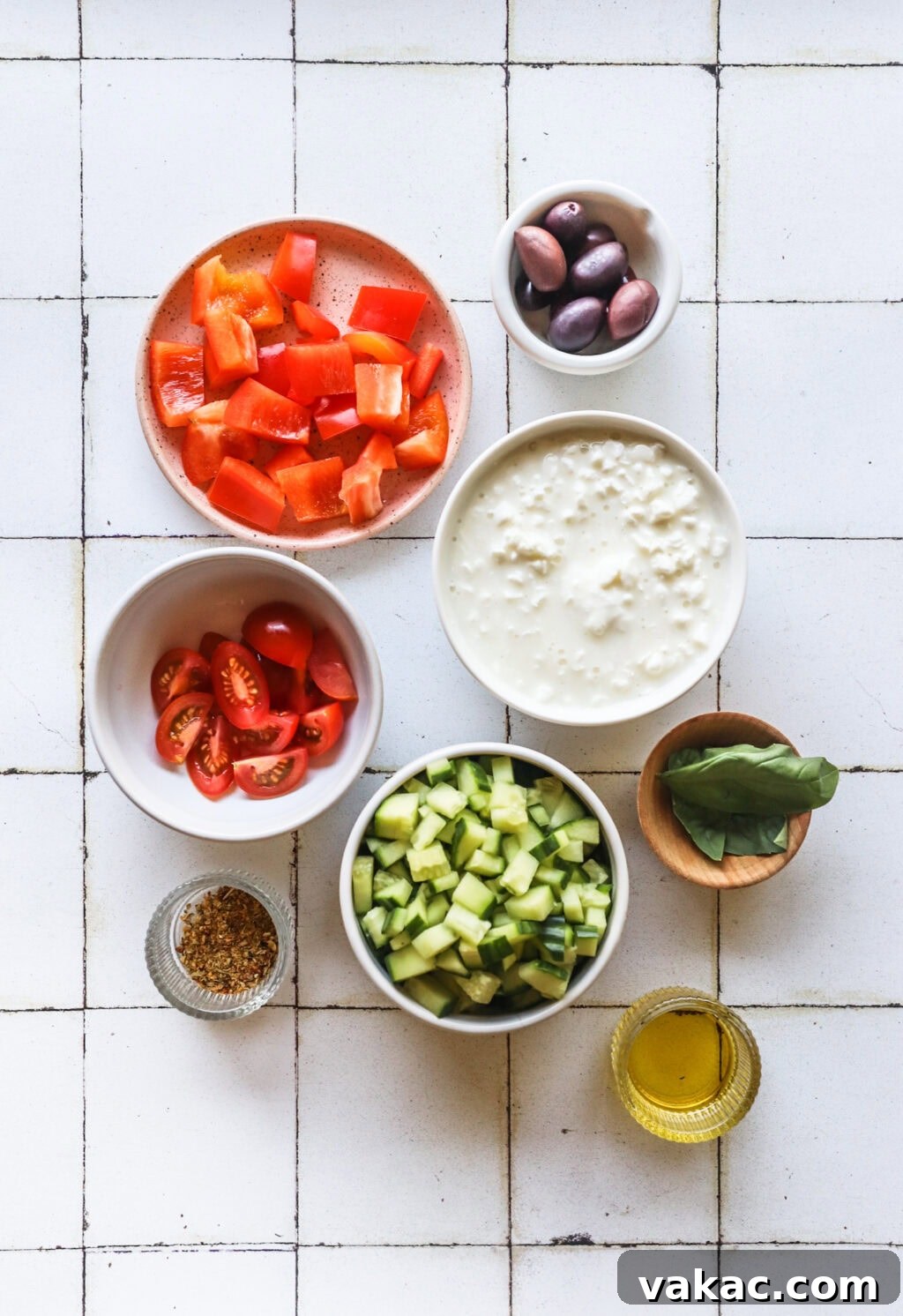 Zesty Mediterranean Cottage Cheese Salad 3 Ingredients for Easy Greek-Inspired Cottage Cheese Salad in small white bowls, including cottage cheese, cherry tomatoes, cucumber, red peppers, olives, Greek seasoning, olive oil, and fresh dill.