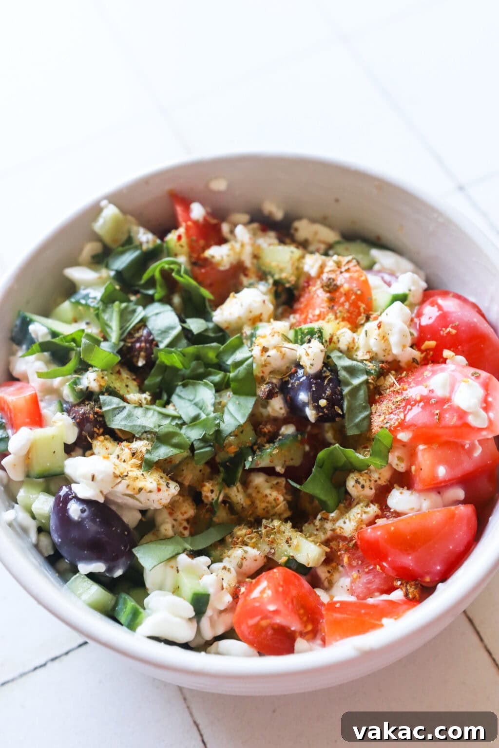 Zesty Mediterranean Cottage Cheese Salad 5 Ingredients for Easy Greek-Inspired Cottage Cheese Salad mixed in a white bowl, showing the combined texture of cottage cheese and vegetables.