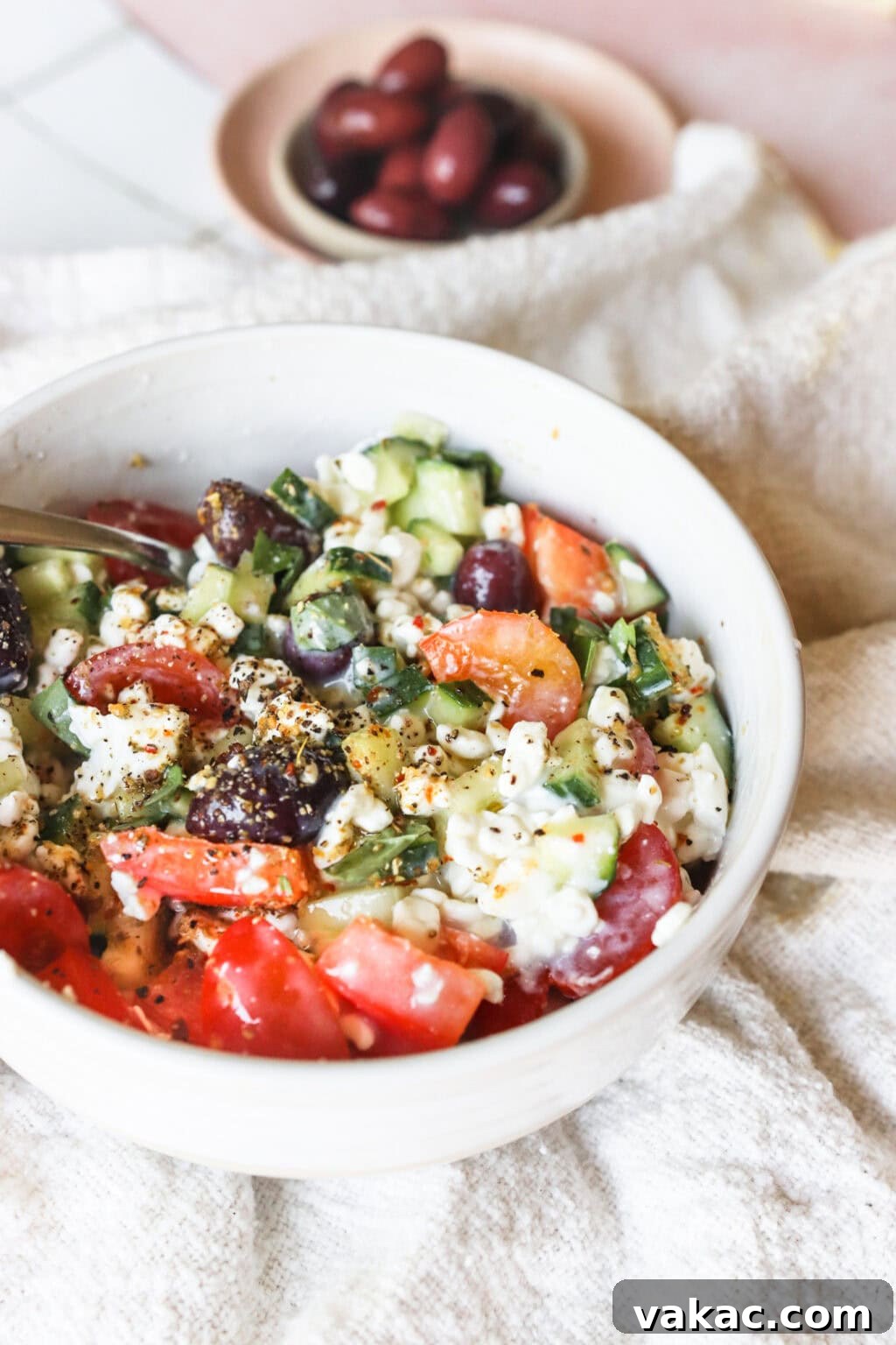 Zesty Mediterranean Cottage Cheese Salad 9 Easy Greek-Inspired Cottage Cheese Salad in a white bowl, showcasing the vibrant colors and creamy texture.