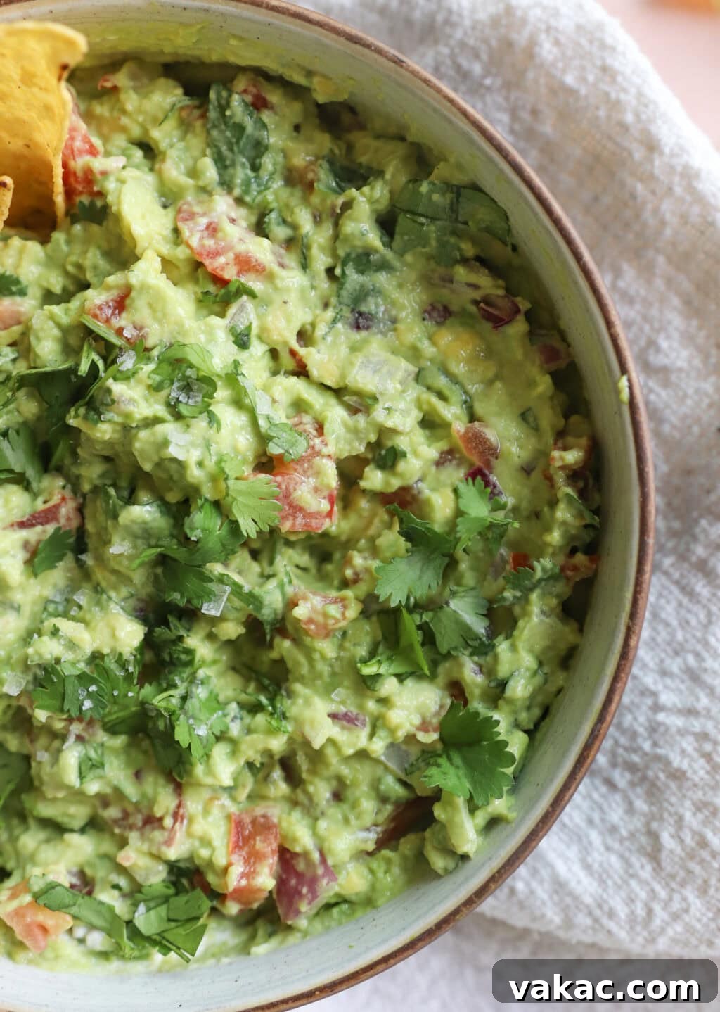 Speedy Creamy Greek Yogurt Guacamole 11 A bowl of creamy 5-Minute Greek Yogurt Guacamole Dip, beautifully garnished with fresh cilantro leaves.