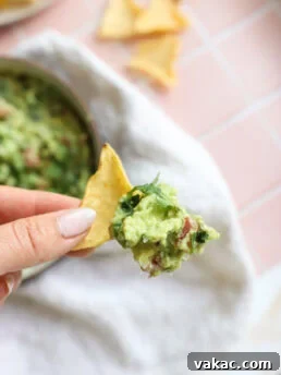Creamy Greek Yogurt Guacamole served on a tortilla chip, illustrating the delicious dip