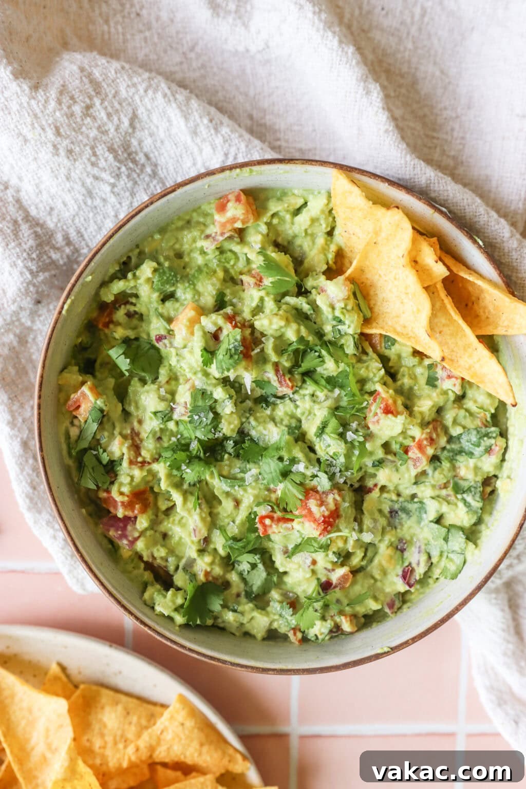 Speedy Creamy Greek Yogurt Guacamole 8 Finished 5-Minute Greek Yogurt Guacamole Dip in a white bowl, garnished with fresh cilantro and a sprinkle of flaky salt
