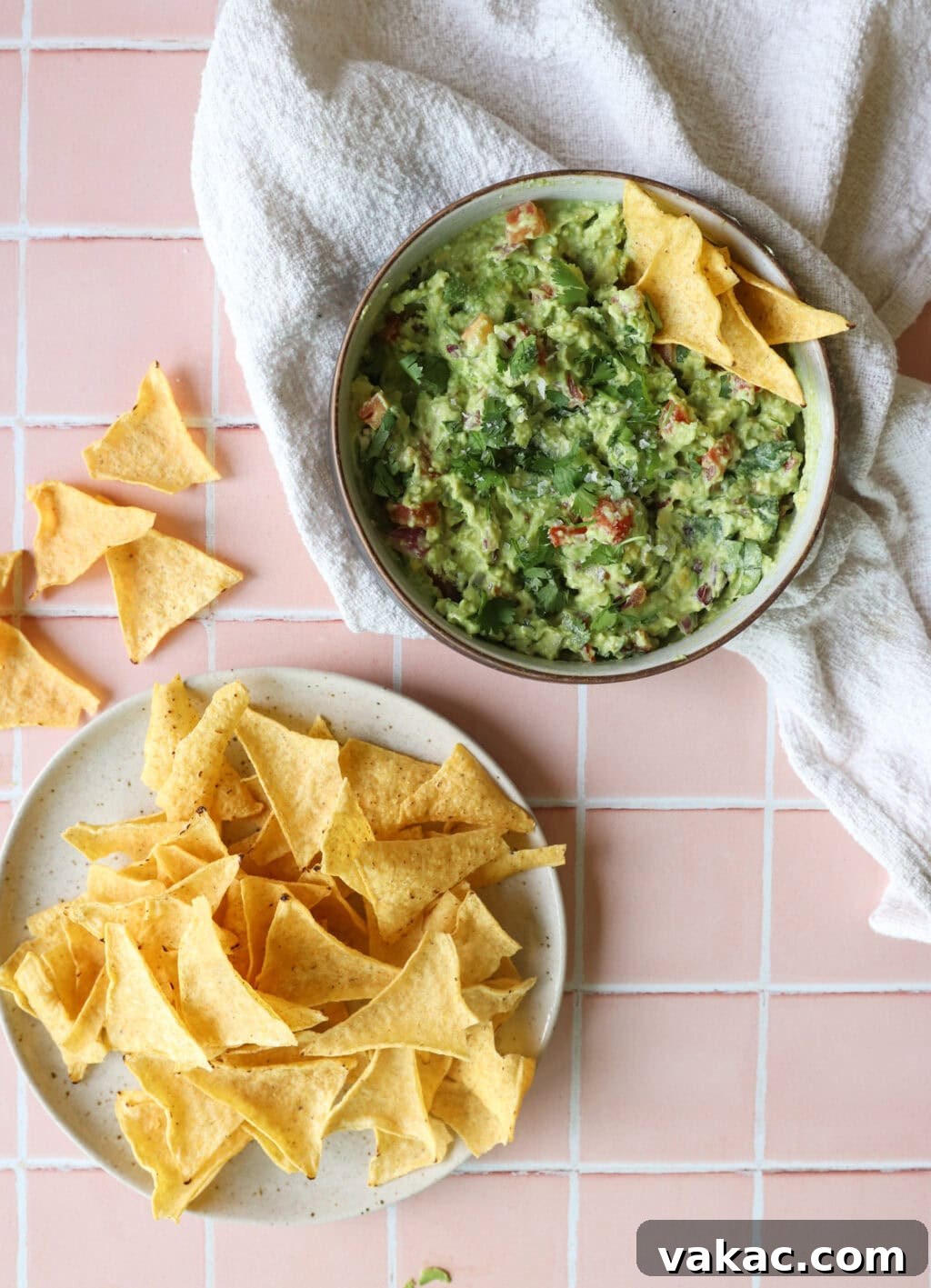 Speedy Creamy Greek Yogurt Guacamole 10 A bowl of creamy 5-Minute Greek Yogurt Guacamole Dip, garnished with cilantro, served alongside a plate of tortilla chips, ready for enjoyment