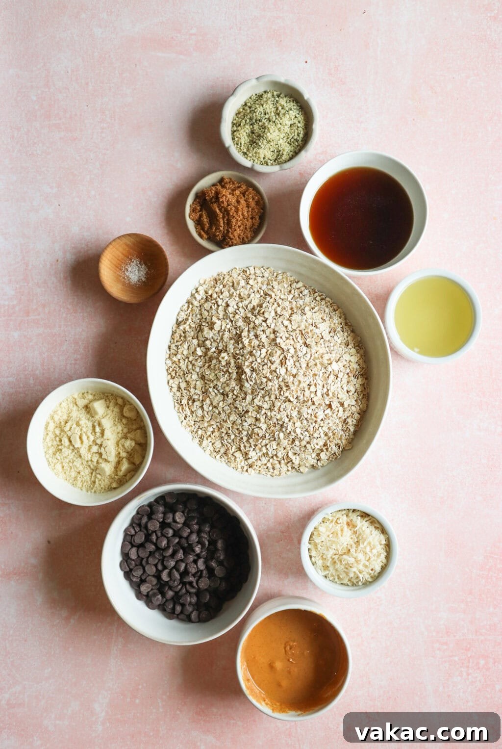 Homemade Heavenly Hunks: So Good, You'll Never Buy Them Again 3 Ingredients for Homemade Heavenly Hunks displayed in individual small bowls, including rolled oats, almond flour, unsweetened coconut flakes, hemp hearts, maple syrup, coconut oil, peanut butter, brown sugar, salt, and dark chocolate chips