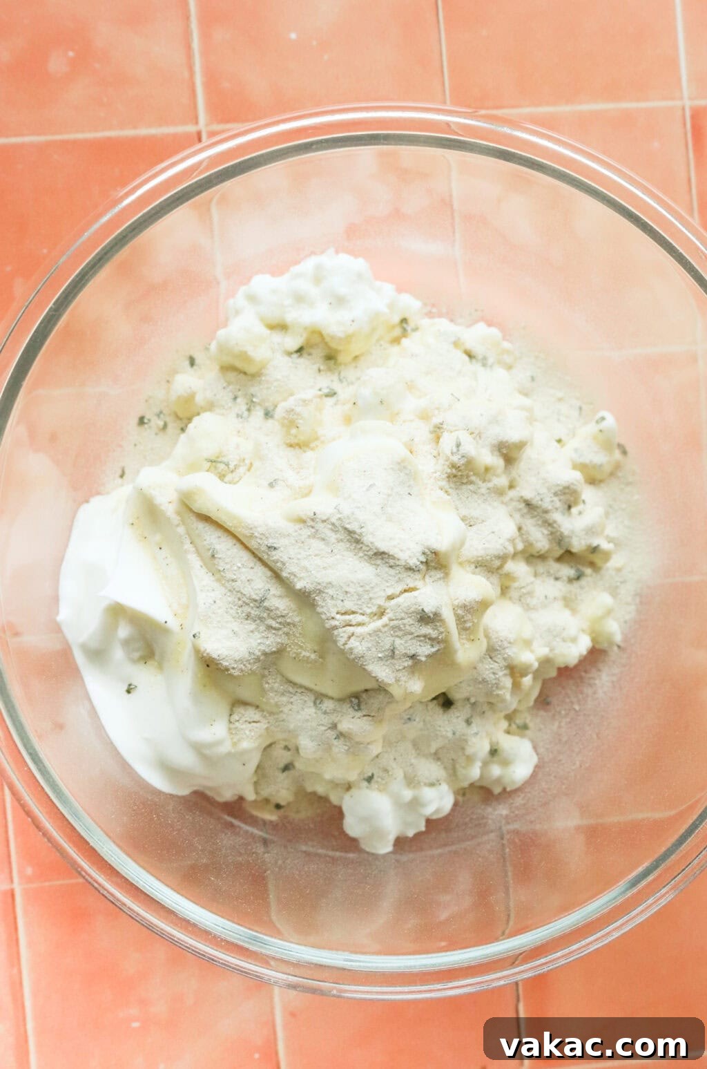 Quick 3-Ingredient Protein Packed Cottage Cheese Ranch Dip 4 ingredients in a glass bowl, on orange countertop, ingredients include; cottage cheese, ranch seasoning pack, salt, and greek yogurt