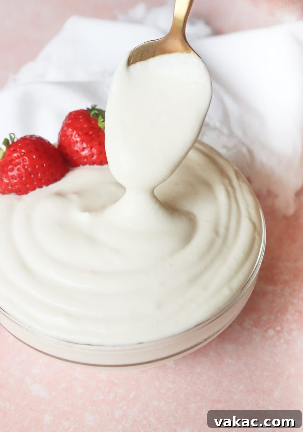 Greek Yogurt Whip: The Speedy, Guilt-Free Dessert Topping 2 A spoon scooping a generous amount of creamy, thick Greek yogurt whipped cream from the bowl, with fresh strawberries on the side for garnish.