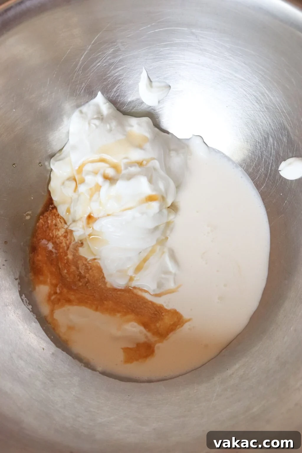 Greek Yogurt Whip: The Speedy, Guilt-Free Dessert Topping 4 A stainless steel mixing bowl containing a blend of Greek yogurt, cream, vanilla extract, and sweetener, ready for whipping