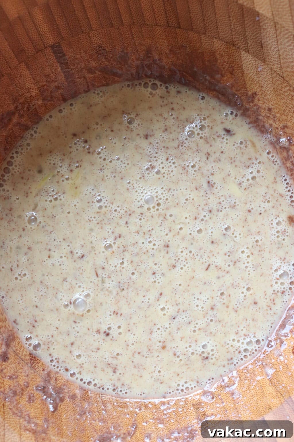 Pillowy Cinnamon-Kissed Sheet Pan French Toast Bake 4 Egg mixture for the sheet pan French toast recipe in a wooden bowl, ready for soaking the bread.