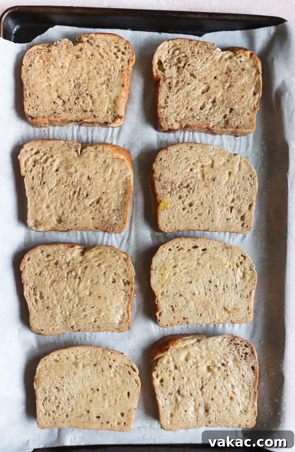 Pillowy Cinnamon-Kissed Sheet Pan French Toast Bake 6 Eight slices of egg-dipped bread neatly arranged on a sheet pan, ready to be baked into French toast.