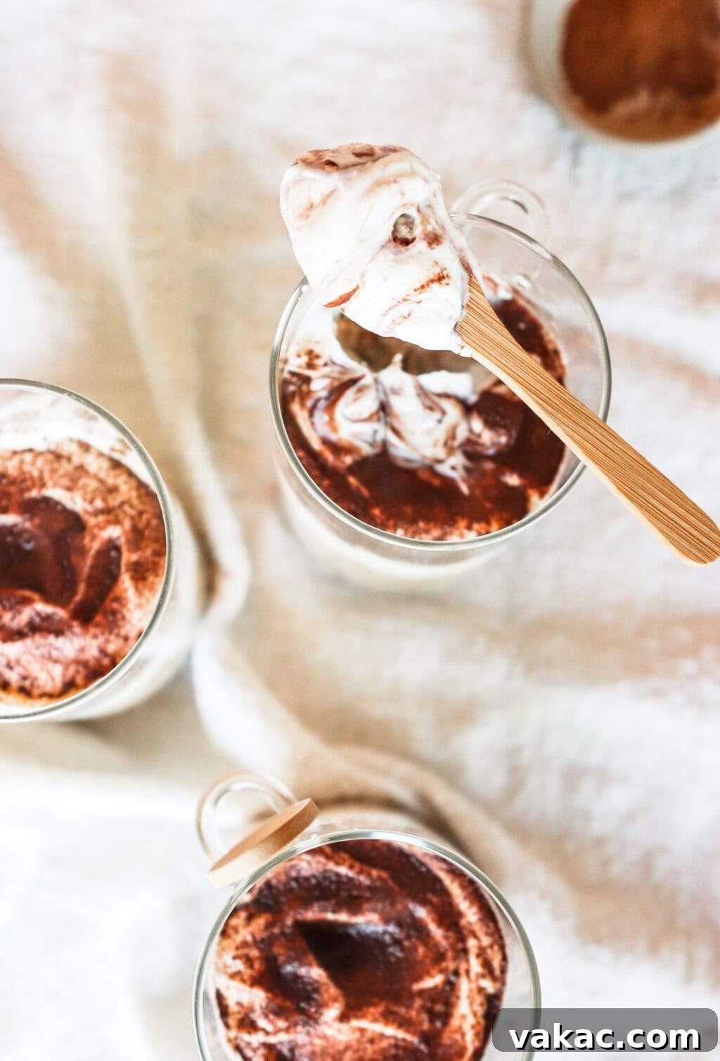 Effortless Tiramisu Overnight Oats with Greek Yogurt 2 An overhead shot of Tiramisu Overnight Oats served in glass jars, with a spoonful showing the creamy texture.