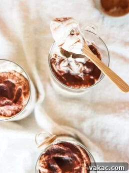 An overhead shot of Tiramisu Overnight Oats in glass jars, with a spoonful of some.