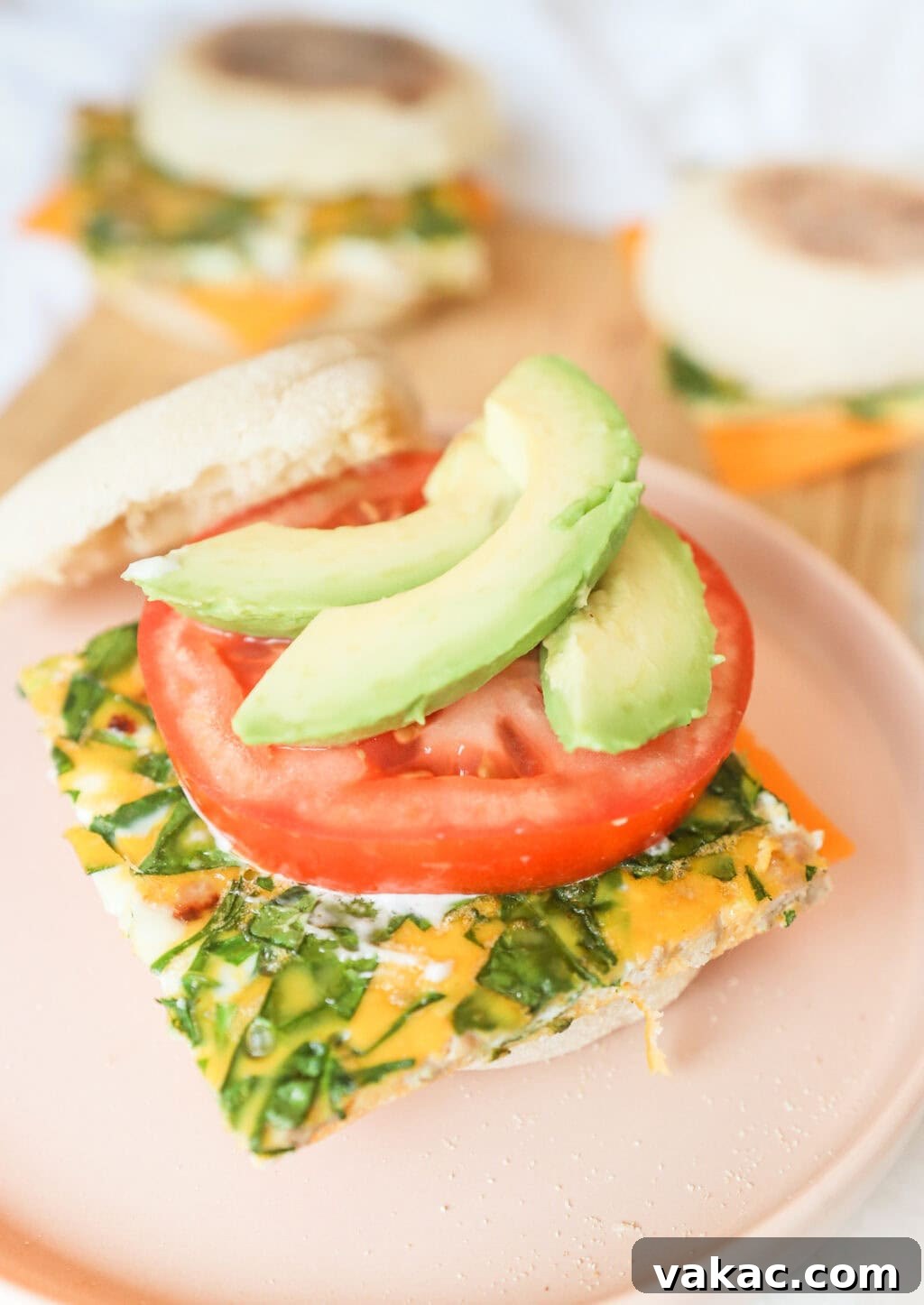 Effortless Turkey Sausage Breakfast Sandwiches 3 Open turkey sausage breakfast sandwich on an English muffin, revealing layers of egg, avocado, and tomato.
