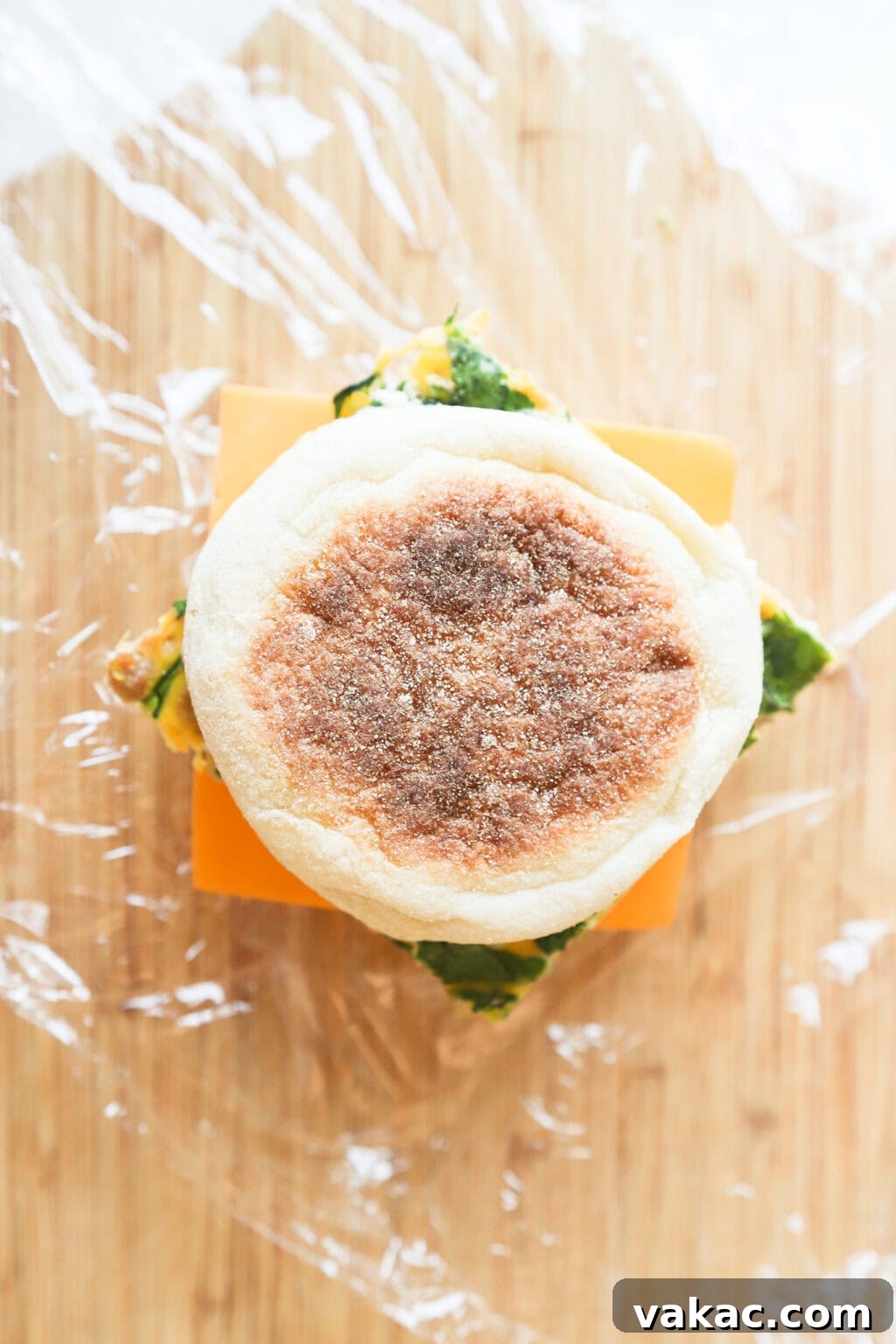 Effortless Turkey Sausage Breakfast Sandwiches 8 Overhead shot of a full turkey sausage breakfast sandwich on a wooden cutting board.