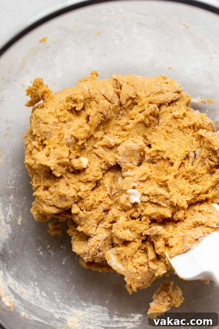 Finished scone batter, perfectly mixed and cohesive, resting in a glass mixing bowl, ready to be shaped into a disc.