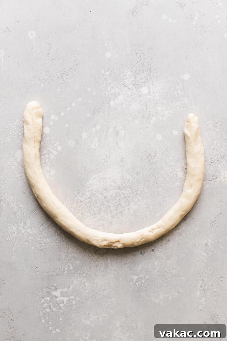 Bakery-Style Soft Pretzels 6 A roll of raw pretzel dough skillfully formed into a perfect U shape, ready for the twist.