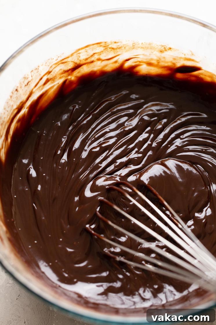 Melt-in-Your-Mouth Truffles 4 Chocolate truffle filling in a glass bowl with a whisk.