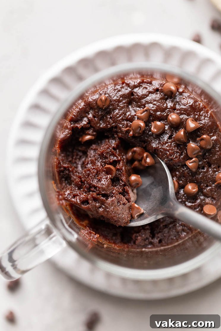 Microwaveable Mug Brownie Bliss 6 Close up, overhead view of a spoon digging into a microwave mug brownie.