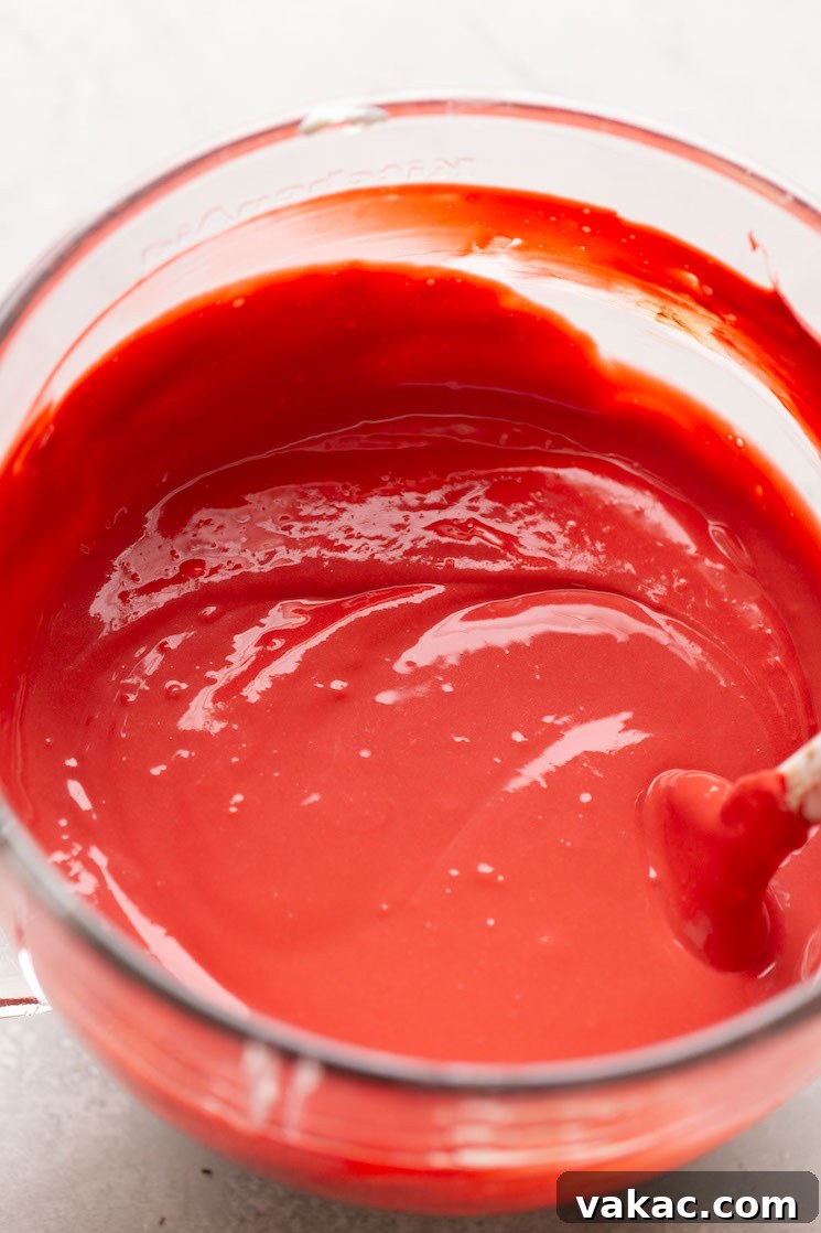 Crimson Dream Cheesecake 5 A glass mixing bowl filled with red velvet cake cheesecake batter.