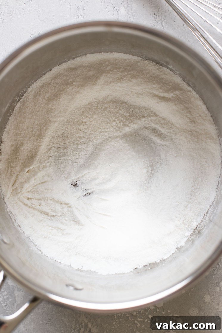Overhead view of a saucepan filled with cornstarch and sugar.