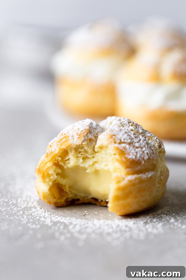 Sweet Cream Clouds 10 A cream puff with a bite missing. More filled cream puffs are on a plate in the background.