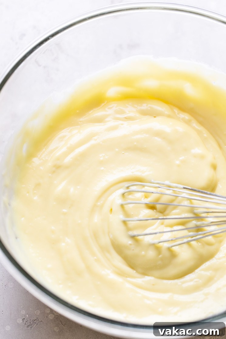 Southern Banana Dream 5 Chilled vanilla pudding in a glass bowl with a whisk.