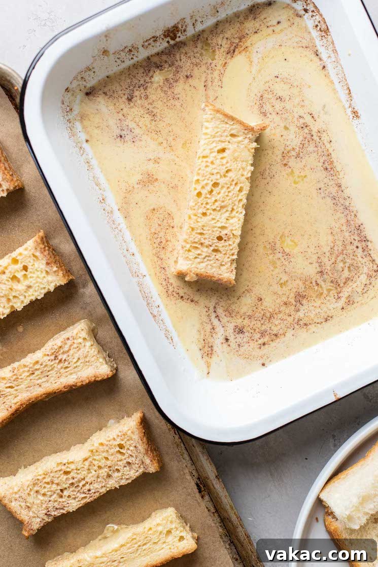 Process shot of Texas Toast slices being dunked one by one into a baking dish filled with french toast batter.