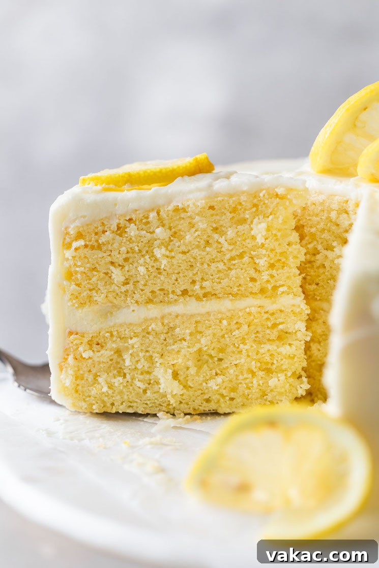 Sunshine Lemon Delight 8 A side view of a slice of lemon cake being removed from a cake stand.