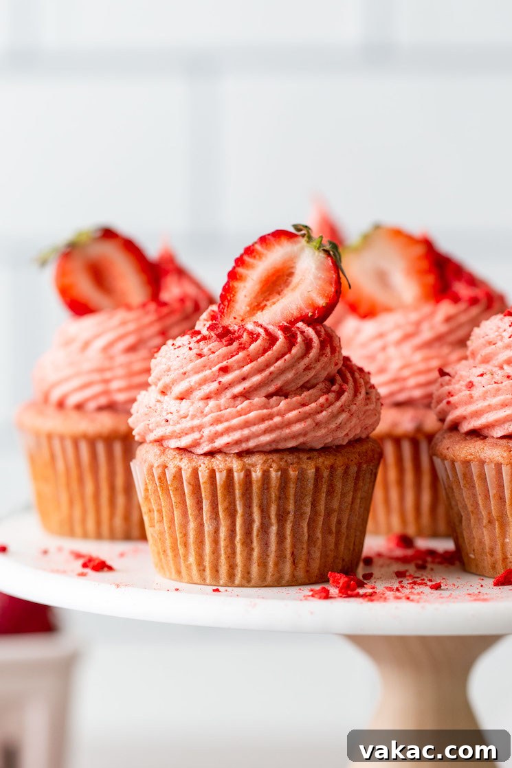 Luscious Strawberry Cupcakes 7 A side view of homemade strawberry cupcakes on a cake stand.