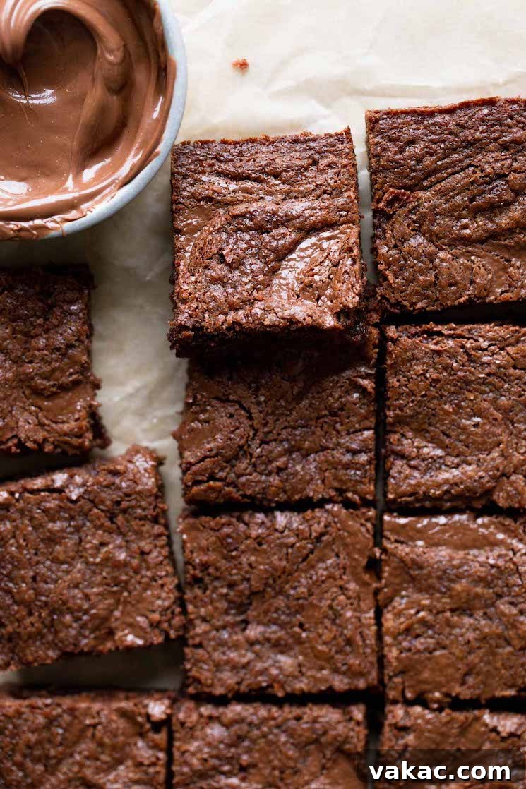 A close up overhead view of sliced Nutella brownies and a dish of Nutella. 