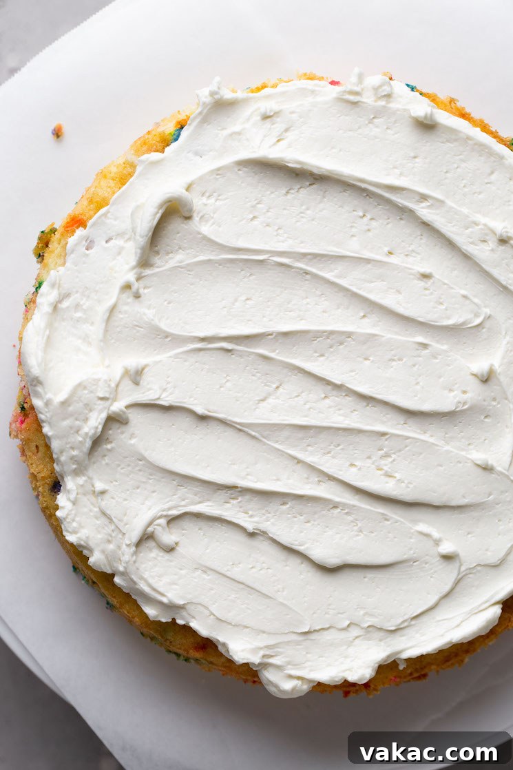 Overhead view of a cake layer topped with frosting.