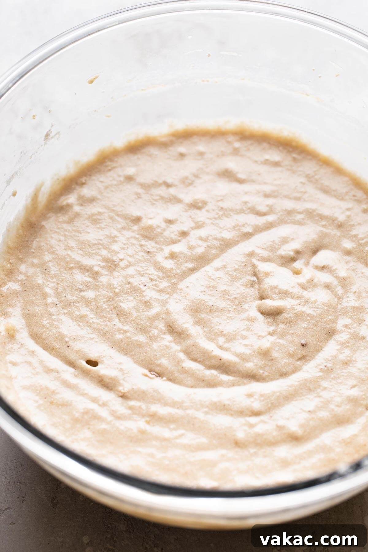 Sweet Banana Bites 4 A glass mixing bowl full of banana cupcake batter.