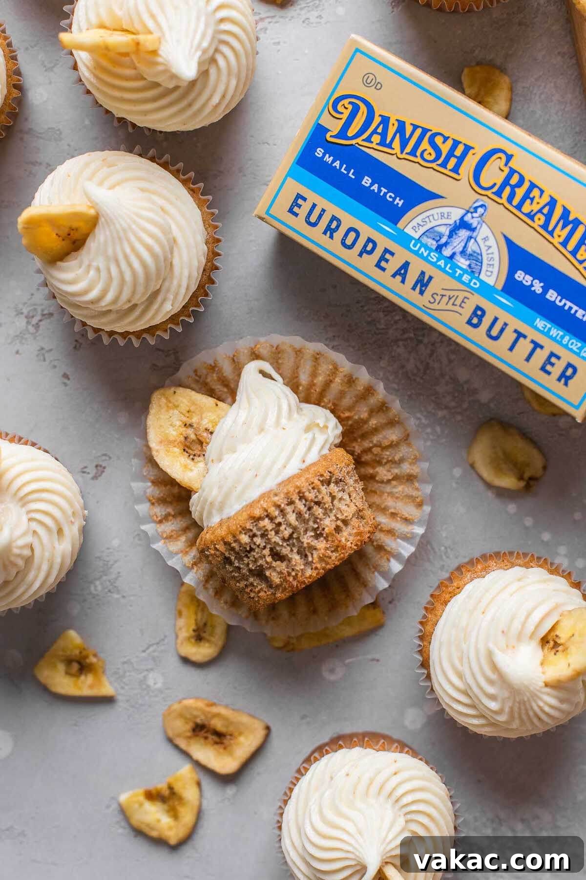 Sweet Banana Bites 7 An overhead view of frosted banana cupcakes with a package of Danish Creamery butter. One cupcake is lying on its side.