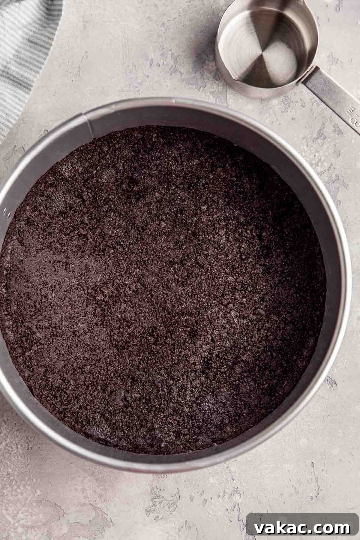 An overhead view of a perfectly formed Oreo cookie crust, pressed evenly into a 9-inch springform pan, awaiting the luscious chocolate filling.
