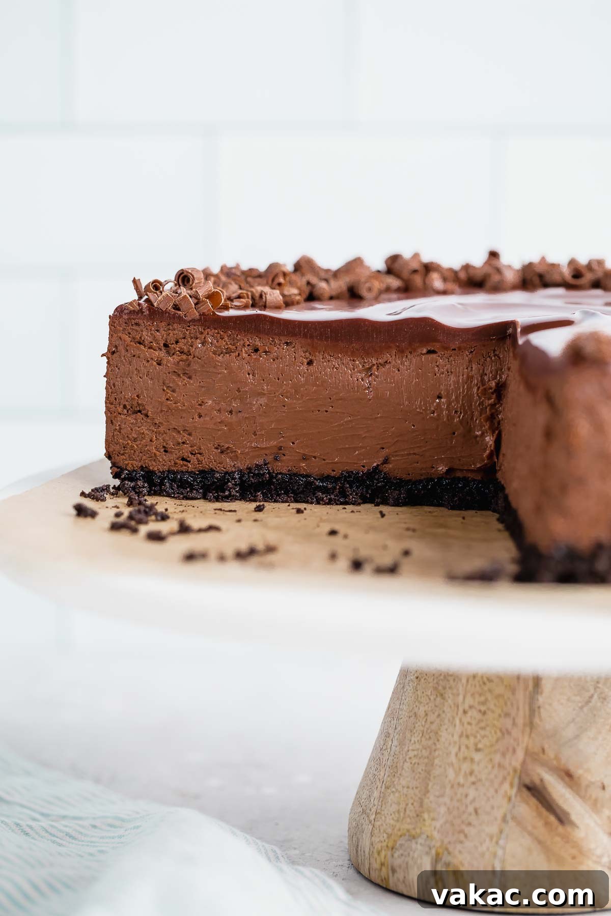 A side view of a perfectly sliced chocolate cheesecake, revealing its creamy layers and rich texture, presented on a elegant marble-top cake stand.