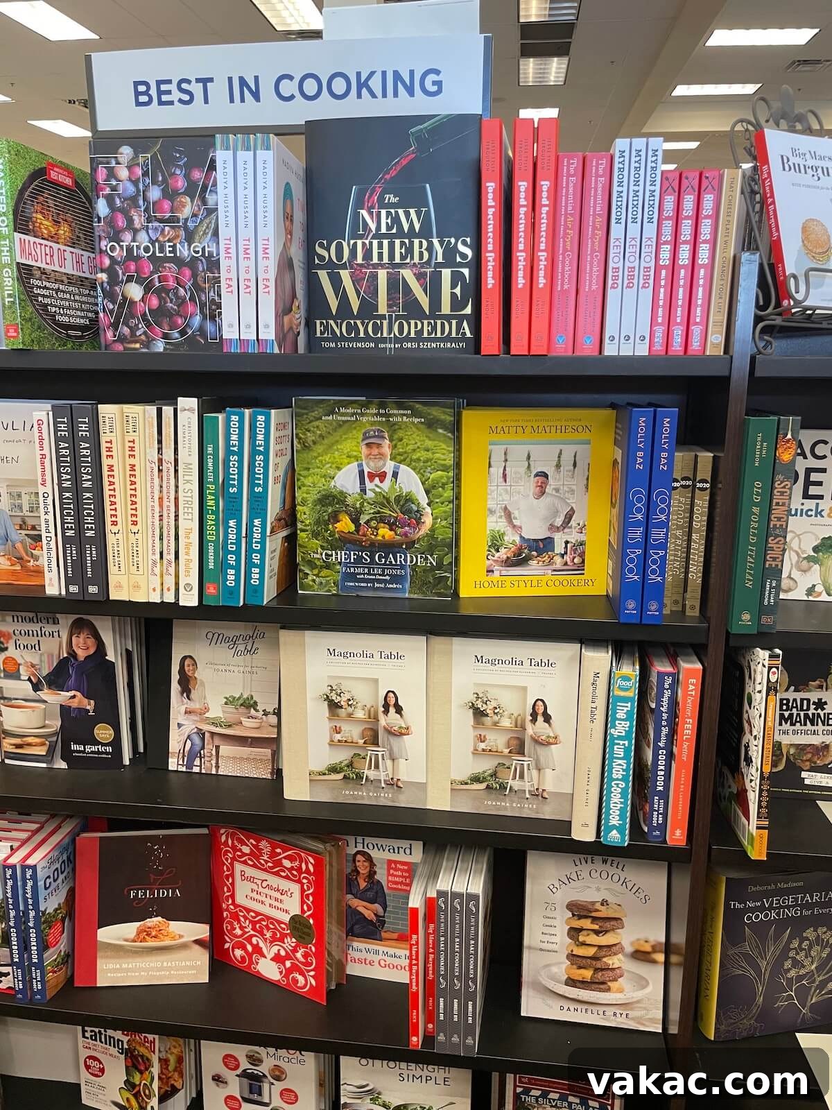 Several copies of cookbooks, including Live Well Bake Cookies, neatly arranged on a shelf in a brightly lit bookstore.