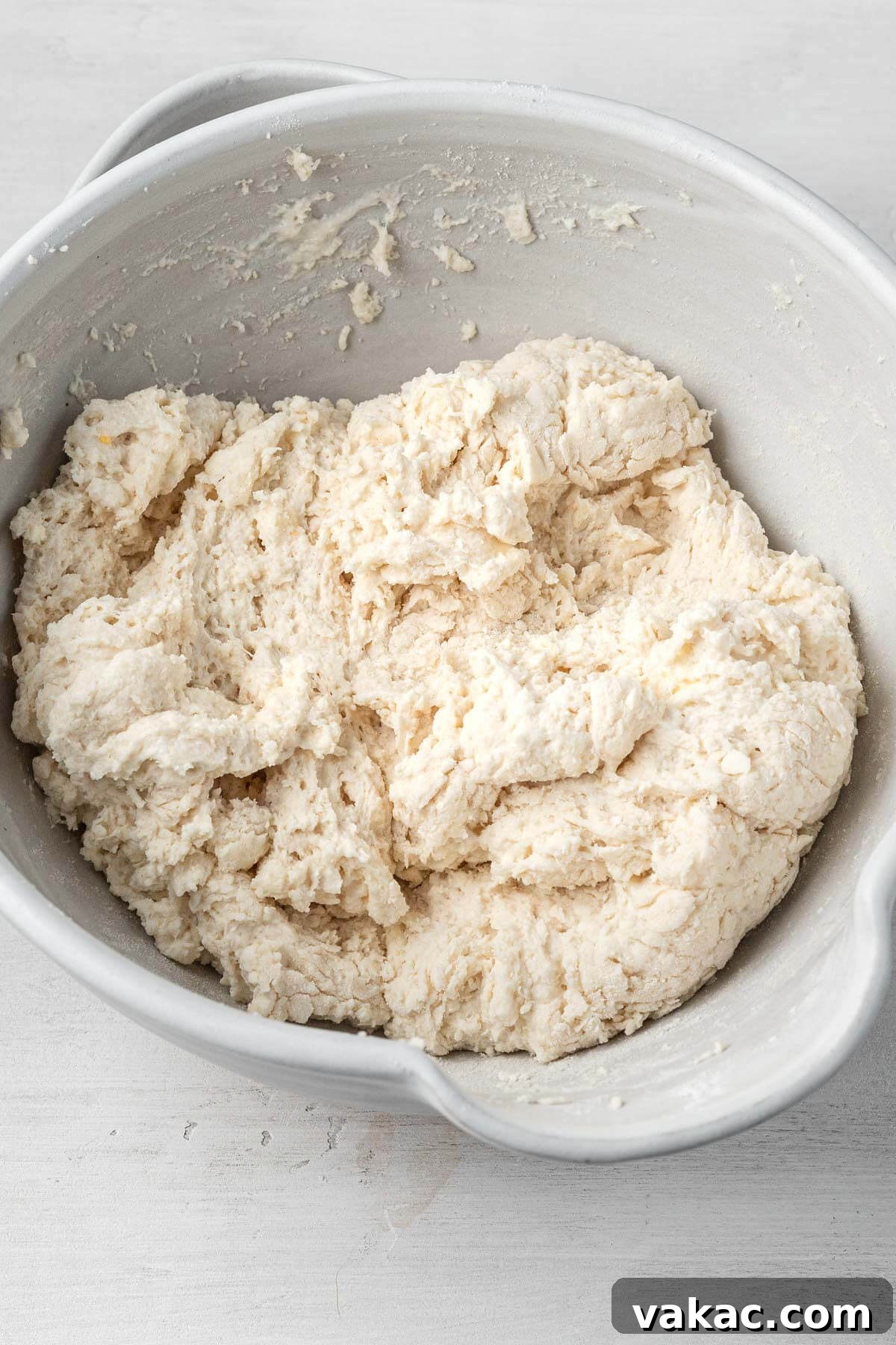 An overhead view of well-mixed drop biscuit dough in a mixing bowl, ready to be scooped.