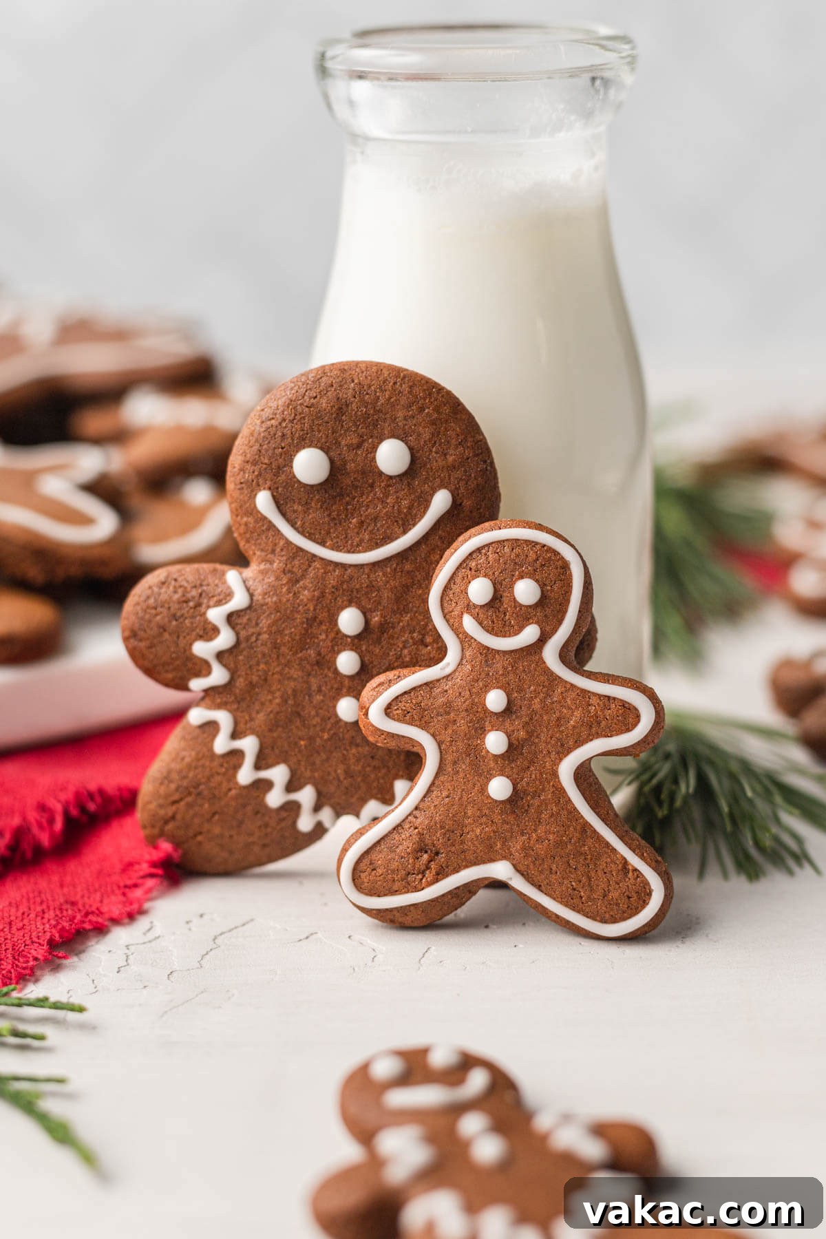 Irresistibly Soft Gingerbread 2 Two soft gingerbread cookies cut into the shape of gingerbread men, stood up in front of a glass jug of milk.
