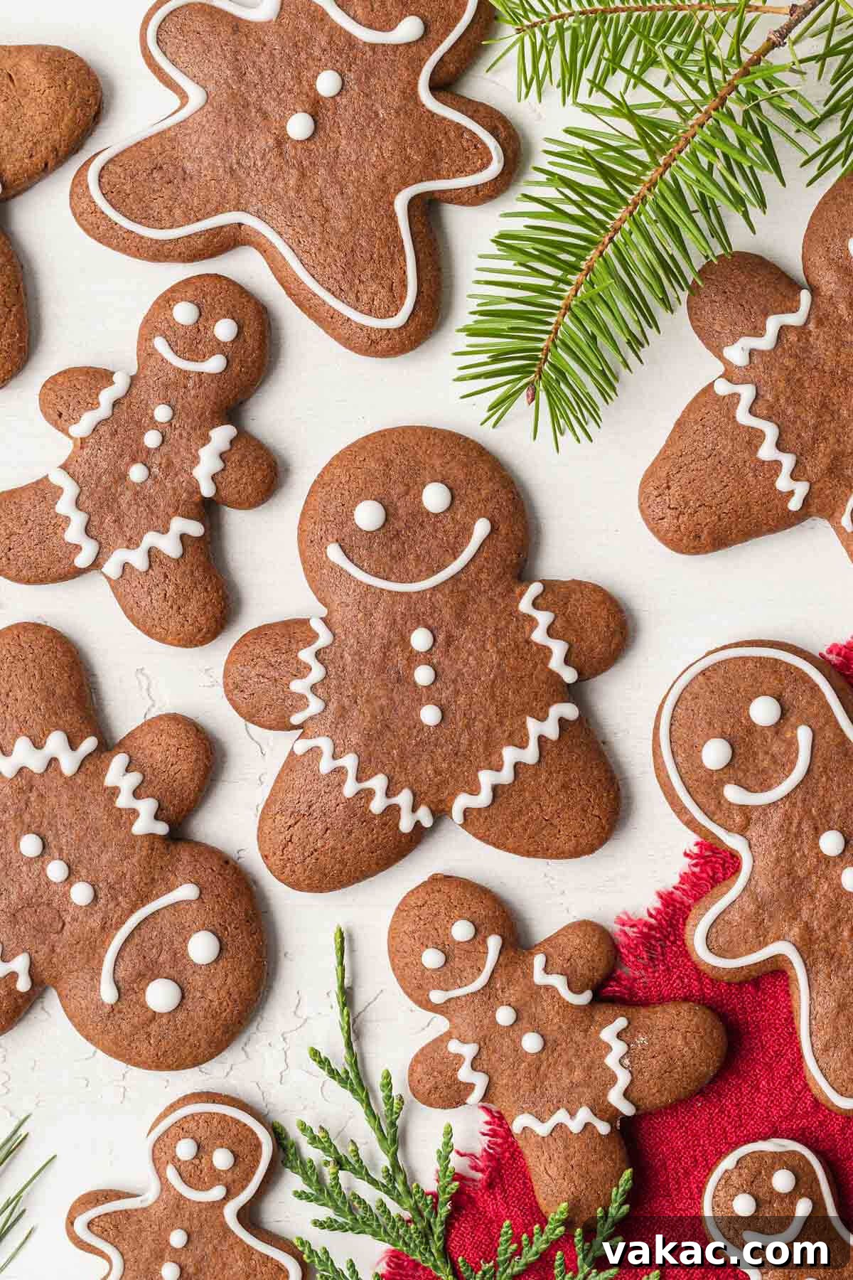 Irresistibly Soft Gingerbread 6 An overhead view of homemade gingerbread cookies topped with icing, with pine branches scattered around.