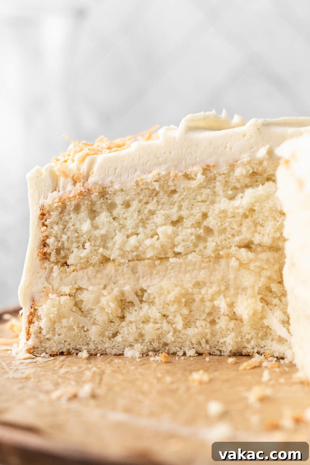 Fluffy Coconut Cloud Cake 9 A side view of a coconut cake that's been sliced to show the interior.