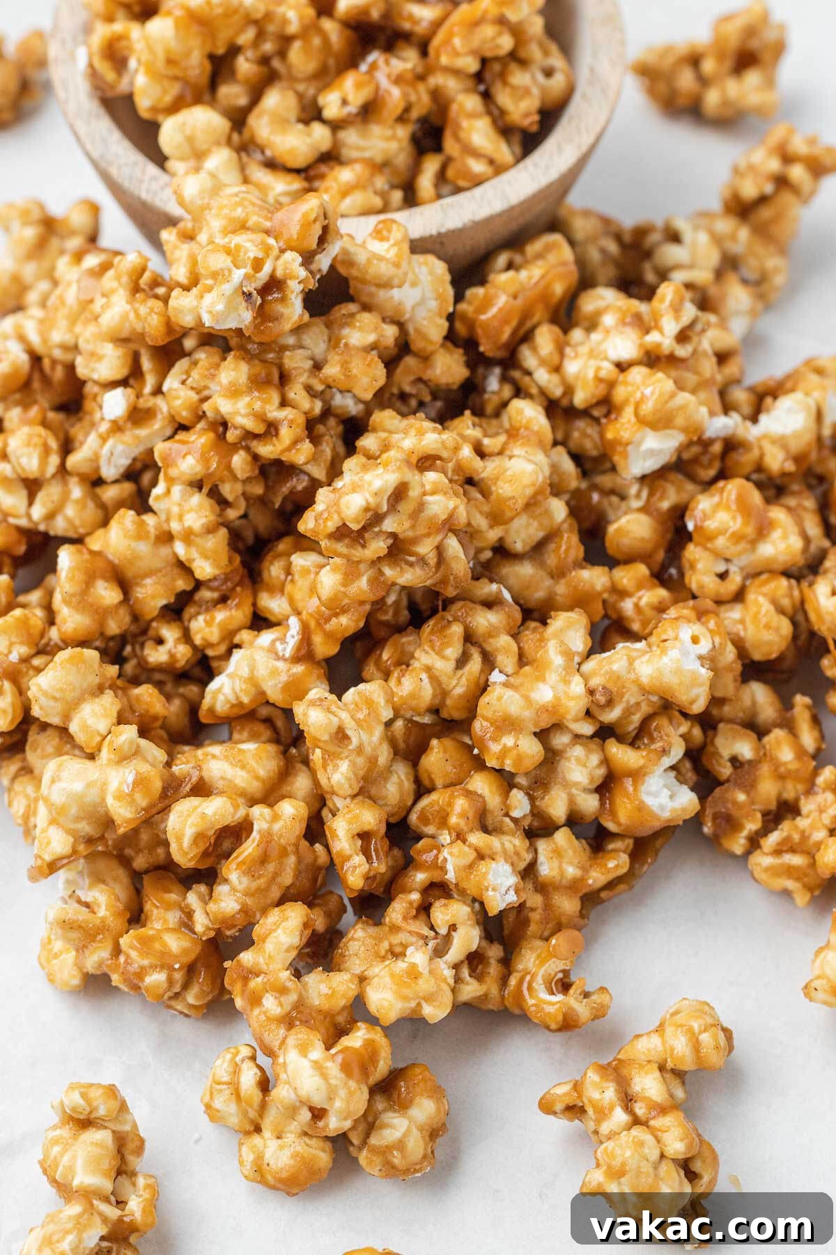 Golden Caramel Popcorn 9 A mound of homemade caramel popcorn next to a small dish of it.