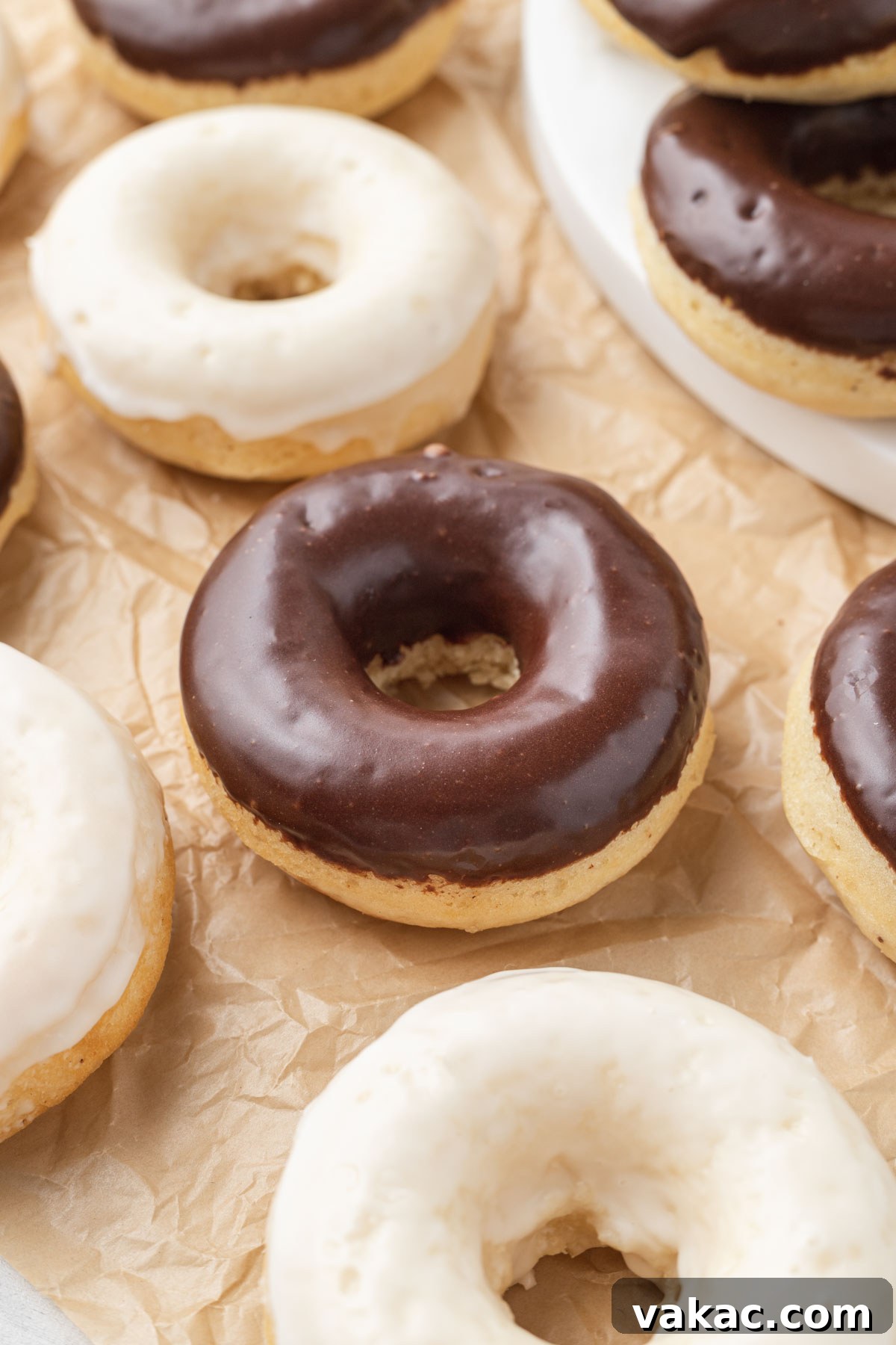 Baked cake donuts with icing on parchment paper. 