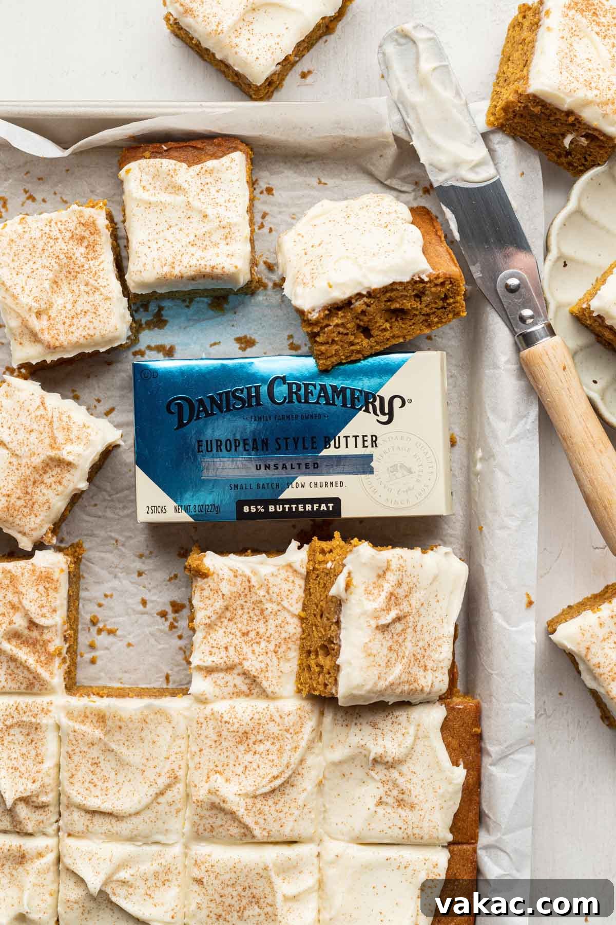 Autumn Spiced Pumpkin Bars 2 Deliciously sliced pumpkin bars with creamy frosting, arranged in a baking pan alongside a package of premium Danish Creamery butter.