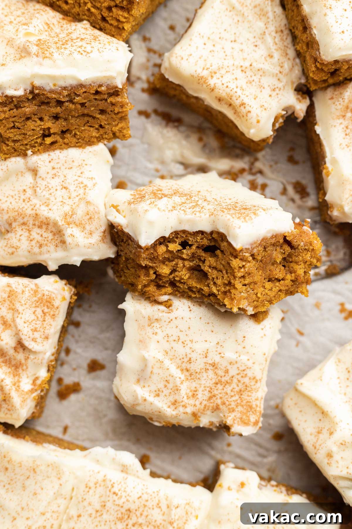 Autumn Spiced Pumpkin Bars 3 Close-up view of frosted pumpkin bars, elegantly sliced and some turned on their sides to showcase their tender texture.