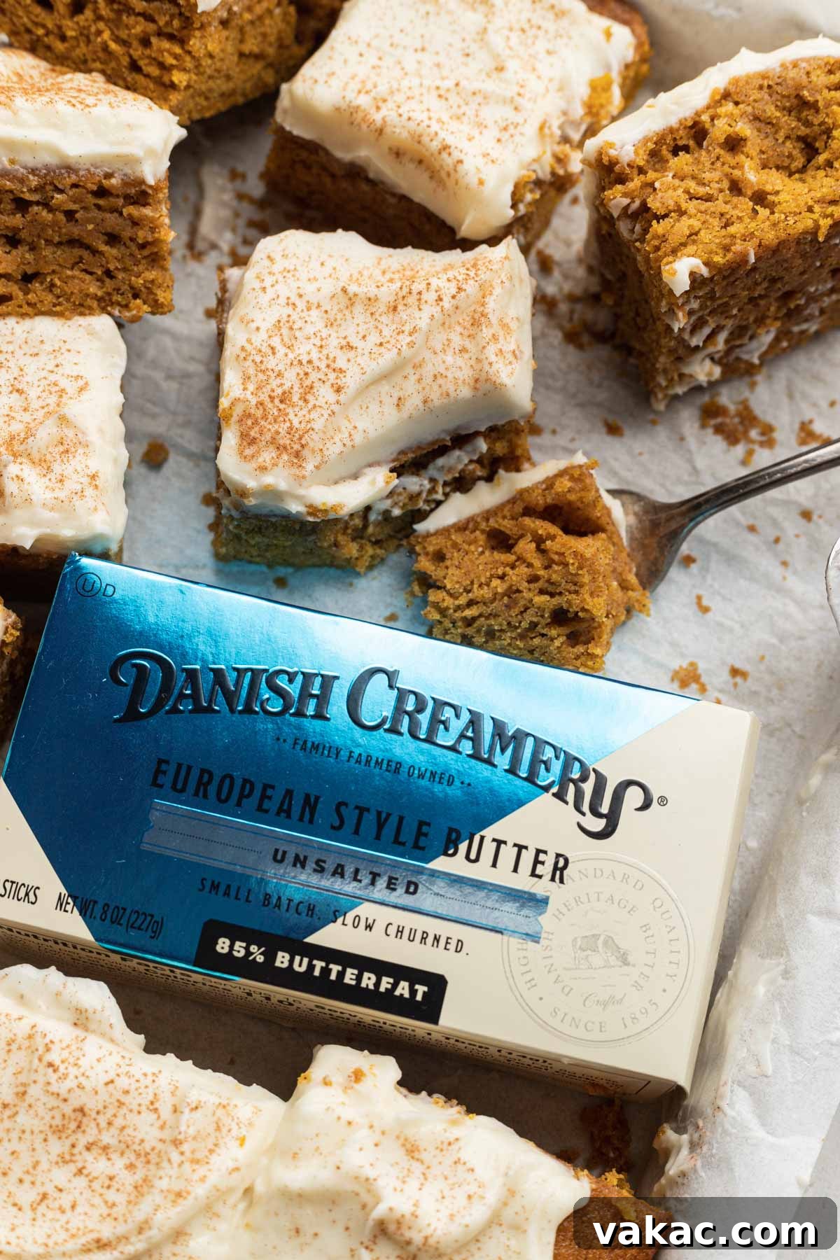 Autumn Spiced Pumpkin Bars 10 A beautifully composed shot featuring a package of premium Danish Creamery butter nestled amidst a selection of perfectly sliced pumpkin bars.