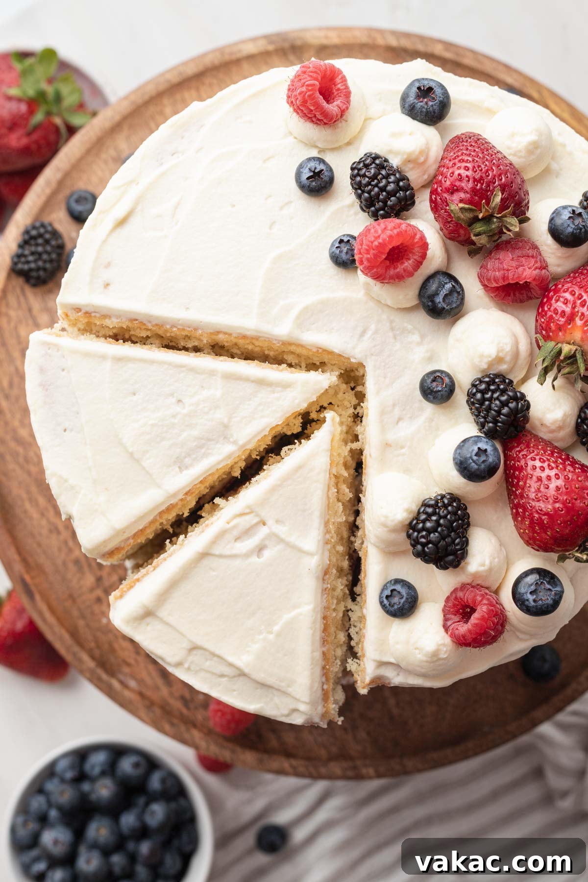 Berry Chantilly Delight 4 An inviting overhead view of a beautifully assembled Chantilly berry cake, with two perfect slices already cut out, revealing its luscious layers of cake, frosting, and fruit.