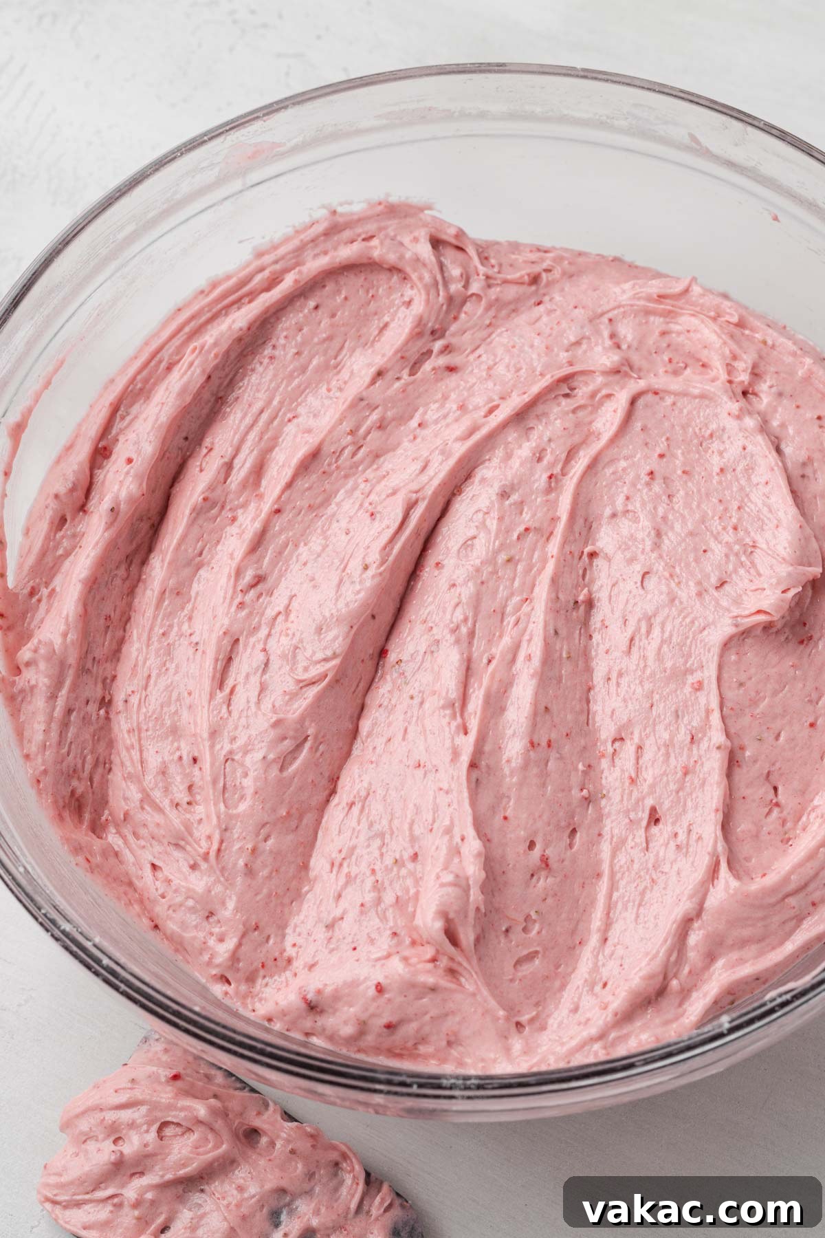 An overhead view of a glass mixing bowl of pound cake batter.