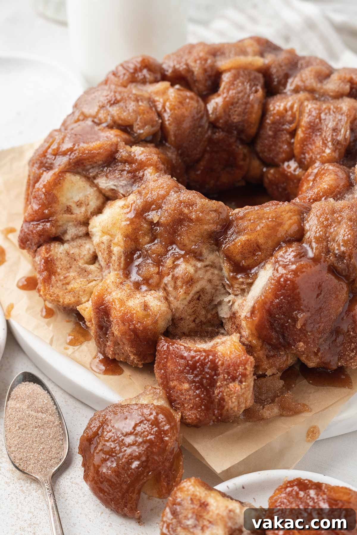 Warm Caramel Pull-Apart Delight 12 Individual pieces of monkey bread pulled off the main loaf, resting on parchment paper, showing the gooey interior.